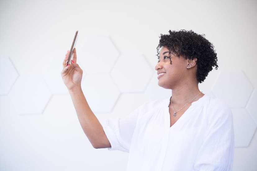 A person holding up a pen and smiling