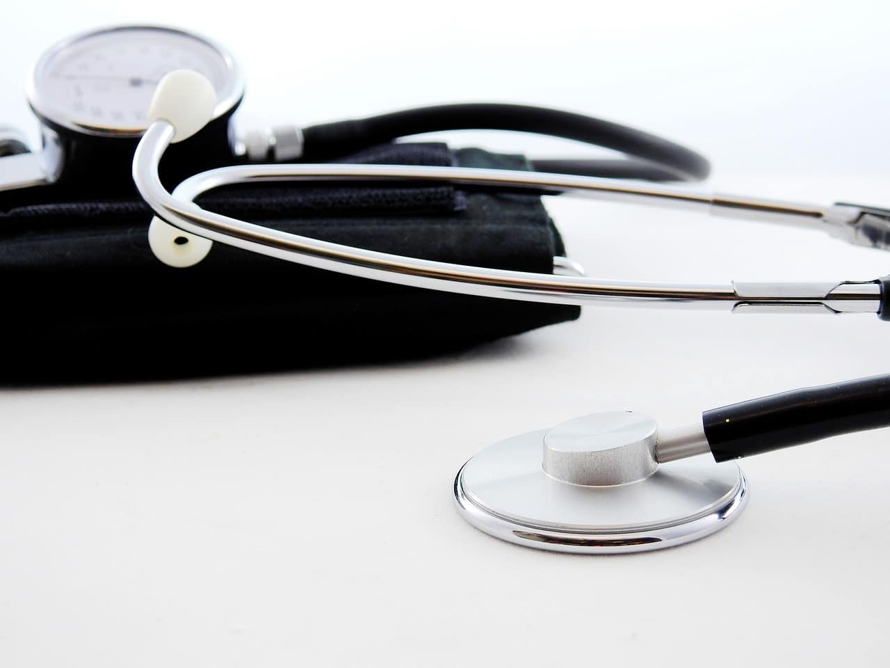 A stethoscope and a blood pressure cuff on a white surface