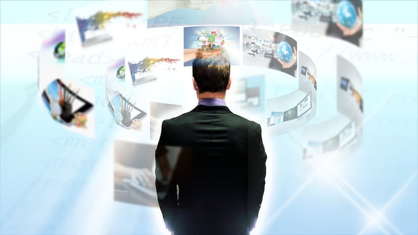 A person in a suit facing a spread of floating digital screens
