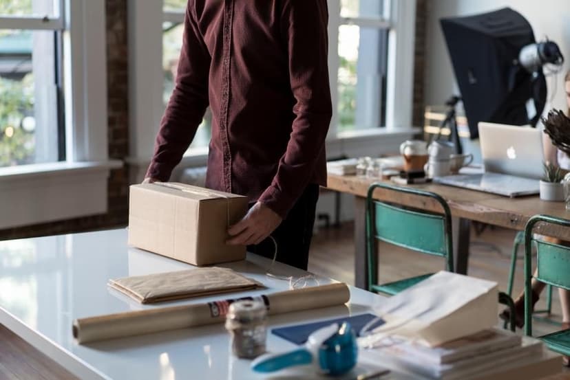 A person carrying a cardboard box in a workshop