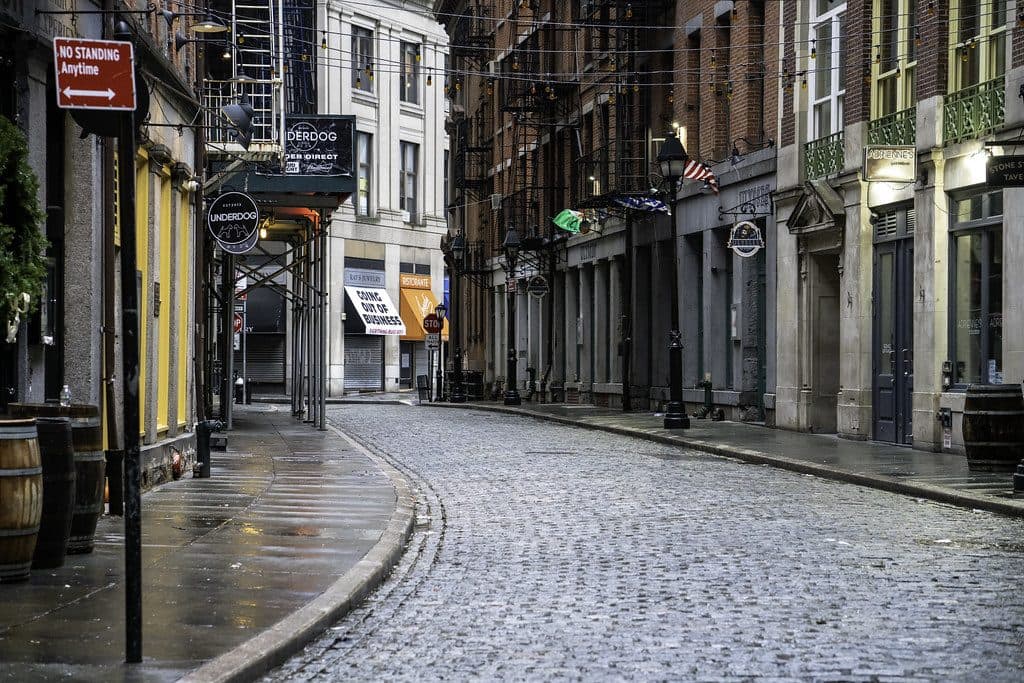 A quiet cobbled street lined with shopfronts