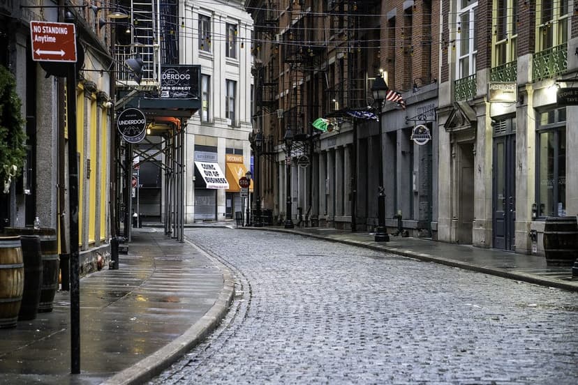 A quiet cobbled street lined with shopfronts