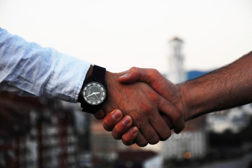 Two people shaking hands outdoors